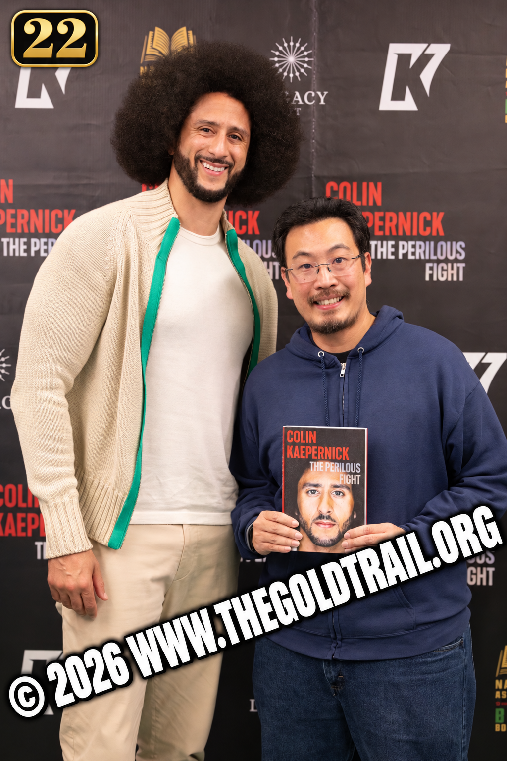 Two men posing with The Perilous Fight book